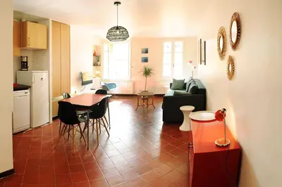 a kitchen and a living room with a table and chairs at Appartement Vieille ville 55 m2 avec Terrasse 16m2 et 2chambres Vraie Climatisation in Aix-en-Provence
