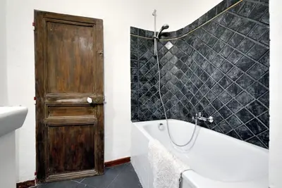 a bathroom with a tub and a shower and a door at Appartement Vieille ville 55 m2 avec Terrasse 16m2 et 2chambres Vraie Climatisation in Aix-en-Provence