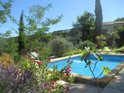 a swimming pool in a garden with flowers at Villa Boulou in Rognes