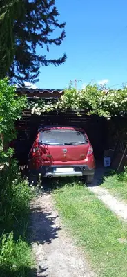 a red car is parked under a hedge at La restanque in La Tour-dʼAigues