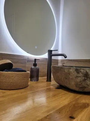 a bathroom with a stone sink and a mirror at Appartement Au cœur de l'Isle in LʼIsle-sur-la-Sorgue