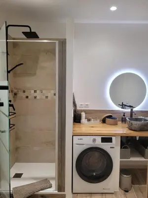 a kitchen with a washing machine and a mirror at Appartement Au cœur de l'Isle in LʼIsle-sur-la-Sorgue