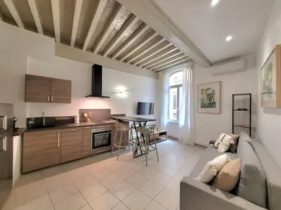 a living room with a couch and a table at Appartement Au cœur de l'Isle in LʼIsle-sur-la-Sorgue