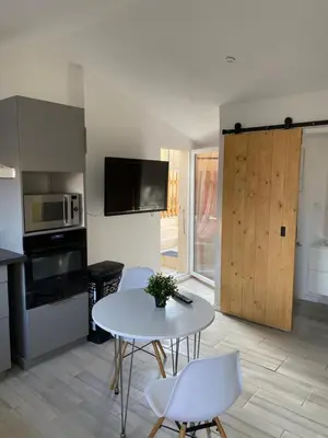 a kitchen with a table and chairs and a microwave at Studio à la campagne in La Tour-dʼAigues