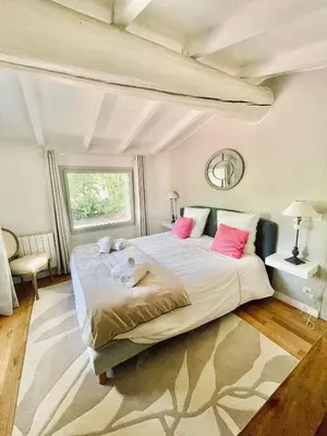a bedroom with a large bed with pink pillows at Zen et Chic, juste à coté de la Bastide de Marie in Ménerbes