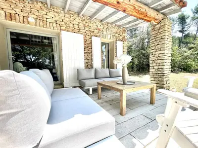 a patio with a couch and a table at Zen et Chic, juste à coté de la Bastide de Marie in Ménerbes