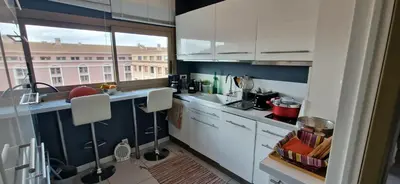 a kitchen with white cabinets and a large window at Le Ciel Bleu Clim Wifi Garage in Aix-en-Provence