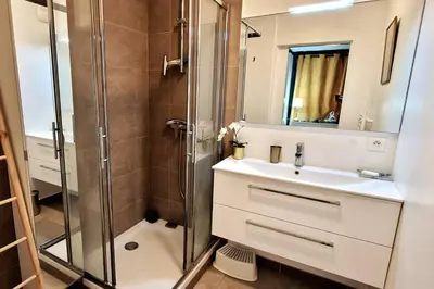 a bathroom with a shower and a sink and a mirror at Le Ciel Bleu Clim Wifi Garage in Aix-en-Provence