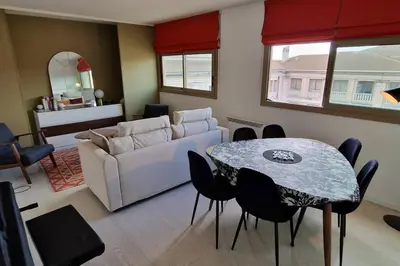 a living room with a white couch and a table at Le Ciel Bleu Clim Wifi Garage in Aix-en-Provence