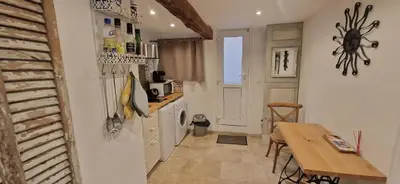 a small kitchen with a table and a refrigerator at Appartement centre historique - climatisé avec extérieur au calme in Aix-en-Provence