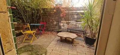 a patio with chairs and a table and a stool at Appartement centre historique - climatisé avec extérieur au calme in Aix-en-Provence