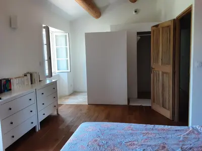 a bedroom with a bed and a dresser and a window at Beau mas en campagne de l'Isle sur la Sorgue in LʼIsle-sur-la-Sorgue