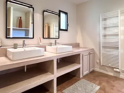 a bathroom with two sinks and two mirrors at La Calade de Goult in Goult