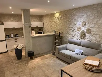 a living room with a couch and a kitchen at Un havre de paix au coeur de la Provence in Châteaurenard