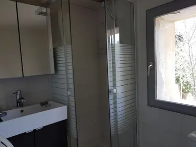 a bathroom with a sink and a glass shower at Les Gites de Catherine in Gargas