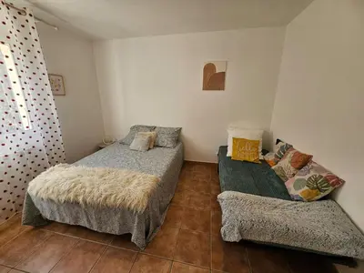 a living room with a couch and a television at Maison des Fenaisons in Entraigues-sur-la-Sorgue
