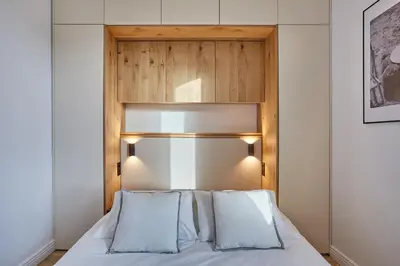 a bedroom with a bed with a wooden headboard at TERRE UGO - Villa & Suites au cœur des lavandes de Provence in Aix-en-Provence