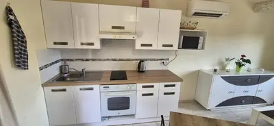 a kitchen with white cabinets and a sink at Restanques de la Tour in La Tour-dʼAigues