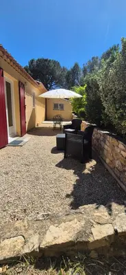 a patio with two benches and an umbrella at Restanques de la Tour in La Tour-dʼAigues