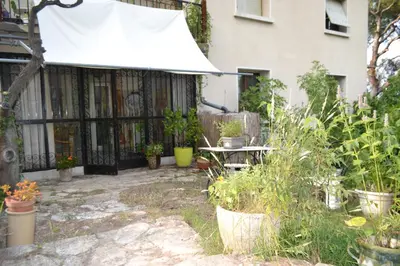a bedroom with a bed and two windows and a radiator at Une Chambre aux Gabions in Cavaillon