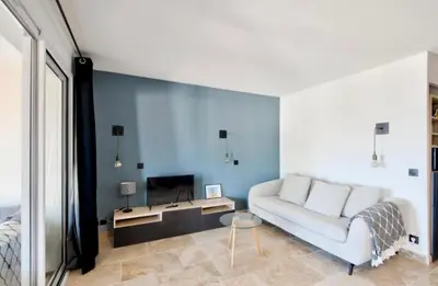 a living room with a white couch and a blue wall at appartement pont royal in Mallemort