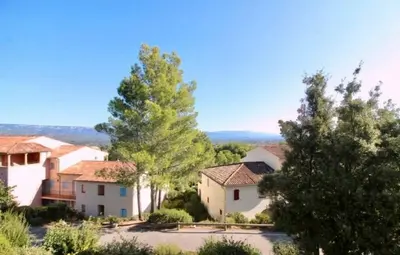 a view of a house with trees in the foreground at appartement pont royal in Mallemort