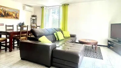a living room with a leather couch and a table at Rendez-vous en Provence -10 personnes- duo de gîtes- piscine privée - clim in Cheval-Blanc