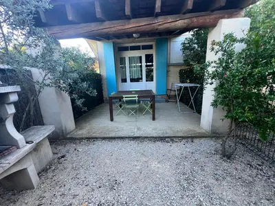 a patio with a table and chairs in front of a house at Domaine Les feuilles de Chêne in Carpentras