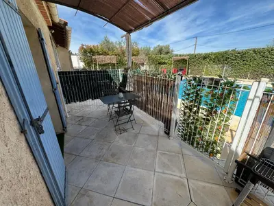 a patio with a table and chairs and a fence at Domaine Les feuilles de Chêne in Carpentras