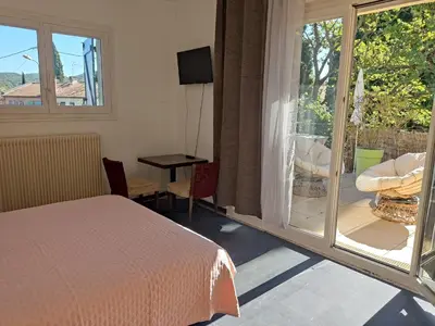 a bedroom with a bed and a sliding glass door at Studio privé confortable avec terrasse, parking et Wi-Fi in Aix-en-Provence