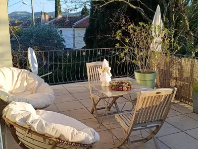 a patio with two chairs and a table with a statue at Studio privé confortable avec terrasse, parking et Wi-Fi in Aix-en-Provence