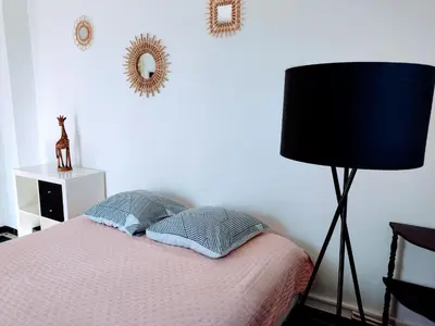 a bedroom with a bed with a lamp and a mirror at Studio privé confortable avec terrasse, parking et Wi-Fi in Aix-en-Provence