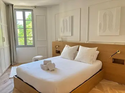a teddy bear sitting on a bed in a bedroom at Le Pénélope in Aix-en-Provence