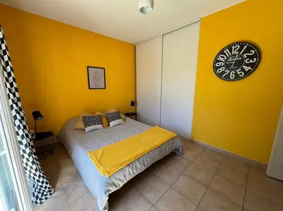 a bedroom with a bed with a clock on the wall at La Villa Nawengo in Le Thor