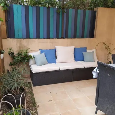a couch with blue and white pillows on a patio at La Villa Nawengo in Le Thor