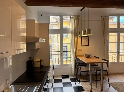 a kitchen with a table and some chairs in a room at Le Prêcheur in Aix-en-Provence