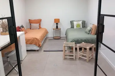 a room with two beds and two stools at Appartement Indépendant avec Jardin et Piscine en Provence in Ventabren