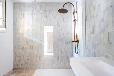 a bathroom with a shower with a white tub at Mas du Loriot in Murs