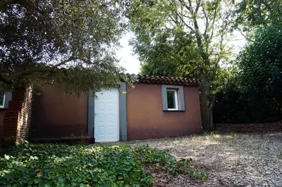 a garage with a white door next to a house at Studio Estrella - Studio 2 personnes - Domaine Astra, Grans in Grans