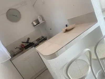 a small white kitchen with a counter and a clock at Studio Estrella - Studio 2 personnes - Domaine Astra, Grans in Grans