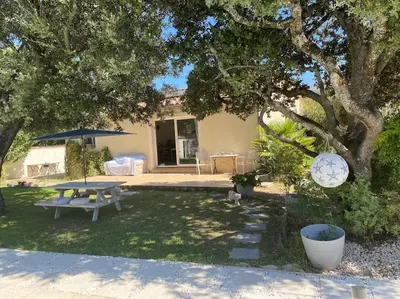 a backyard with a table and a picnic table and a tree at Maison de Vacances en Provence in Venasque