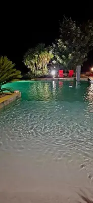 a large pool of water at night with red chairs at Studio Soléa - Studio 2 - 4 personnes - Domaine Astra, Grans in Grans