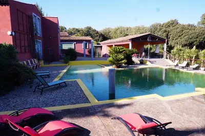 a swimming pool in front of a building with a house at La Villa Astra de 4 à 12 personnes - Domaine Astra, Grans in Grans