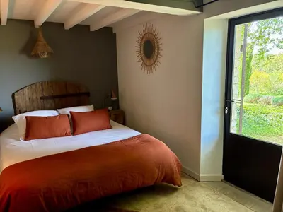 a bedroom with a bed with red pillows and a window at Chambre dans bastide au milieu des vignes in Ménerbes