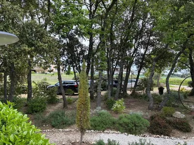 a car parked in a parking lot next to trees at Chambre dans bastide au milieu des vignes in Ménerbes