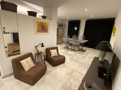 a living room with two chairs and a table at T3 au pied des Tours du Château in Châteaurenard