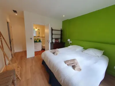 a green bedroom with a bed with towels on it at Le grand mas du Couchadou in Pernes-les-Fontaines