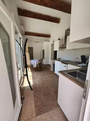 a kitchen with a sink and a table in a room at Escapade en maisonnette indépendante avec piscine in Châteaurenard