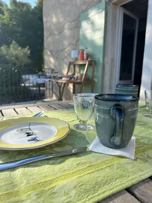 a table with a plate and a coffee cup on it at Au Clair Ventoux B & B - SPA in Saint-Didier