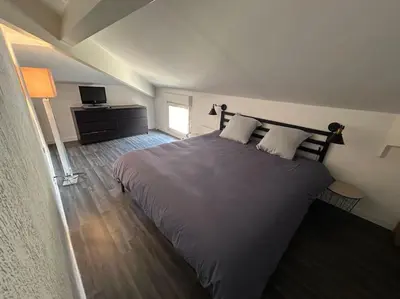 a bedroom with a large bed and a television at Magnifique Duplex à proximité Aix en Provence in Éguilles